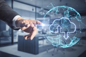 Businessman pointing at a cloud storage icon representing data backup
